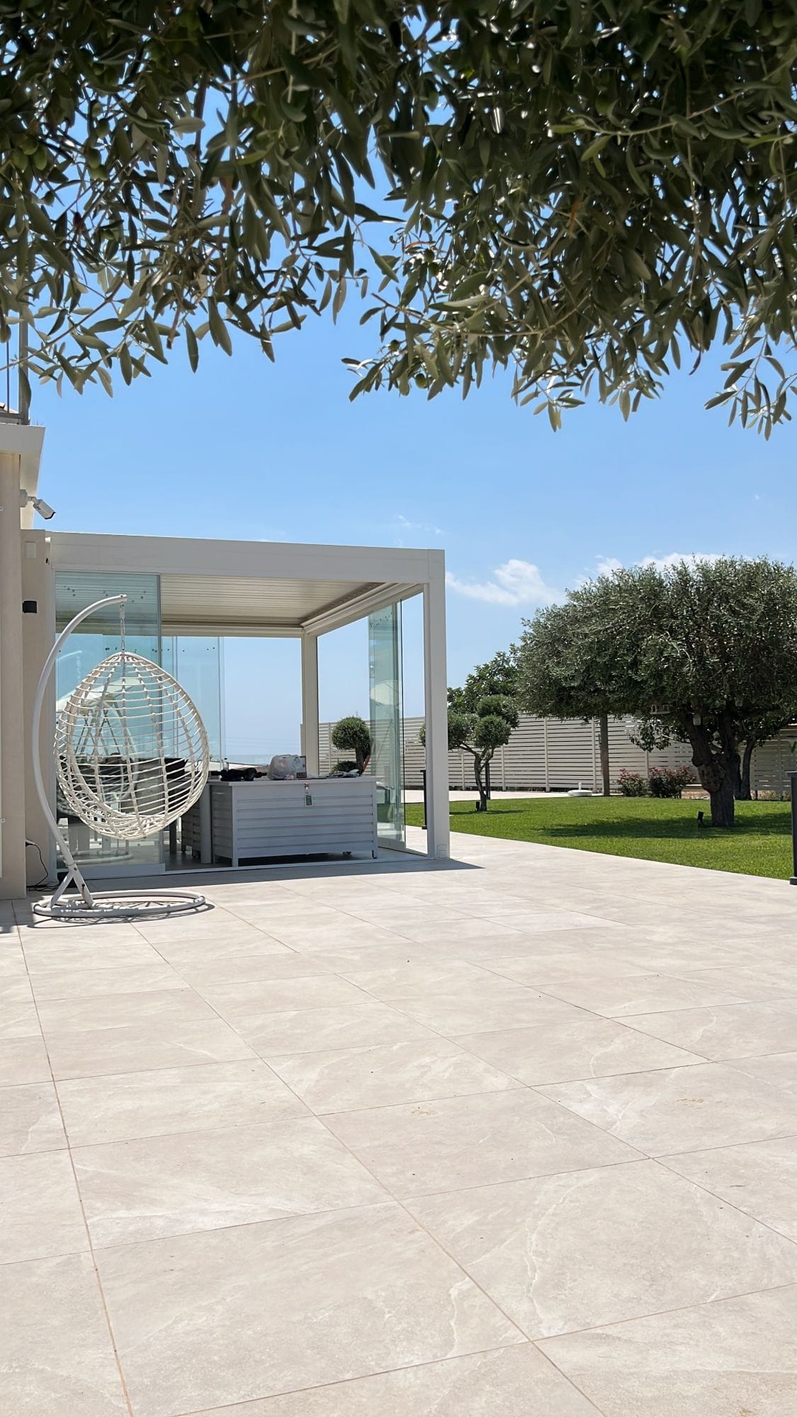 Pergola bioclimatica con vetrate scorrevoli in un giardino